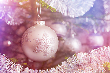 Image showing Christmas-tree decoration bauble on decorated Christmas tree bac