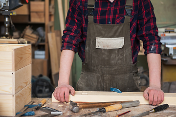 Image showing Carpenter working with a chisel