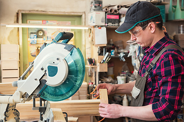 Image showing Carpenter worker cutting wooden board