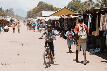 Image showing Young boy riding bicycle on street. Madagascar