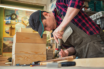 Image showing Carpenter working with a chisel