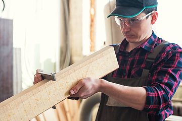 Image showing The worker makes measurements of a wooden board