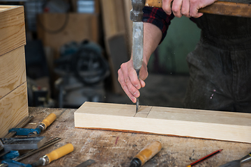 Image showing Carpenter working with a chisel