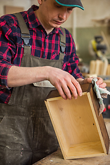 Image showing Carpenter painting wooden