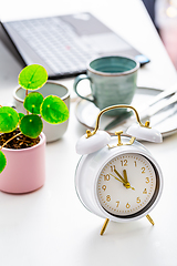 Image showing Time management and procrastination concept. Composition with alarm clock on white desk, laptop computer