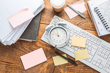 Image showing Time management concept. Composition with alarm clock on wooden table with laptop computer, stationary and post-it notes