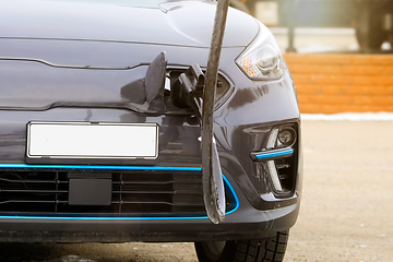 Image showing Electric Vehicle Plugged in at Charging Station