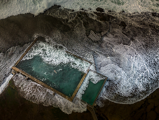 Image showing Incoming tide waves crash over the rock pool at Mona Vale