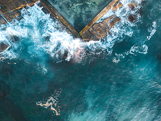 Image showing Ocean waves splash onto rocks and into the tidal pool