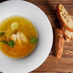 Image showing Meat broth with chicken meat, egg and parsley in a white bowl, b