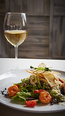 Image showing Fresh caesar salad on white bowl with parmesan cheese and shrimp