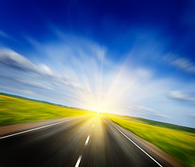 Image showing Motion blurred road in blooming spring meadow