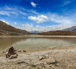 Image showing Trekking hiking boots at mountain lake in Himalayas