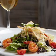 Image showing Fresh caesar salad on white bowl with parmesan cheese and shrimp