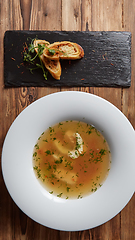 Image showing Beautiful presentation of the fish soup in a white plate, with b