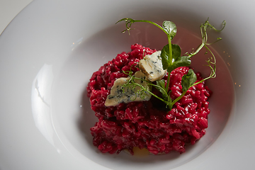 Image showing Beetroot risotto with blue cheese on a white plate.