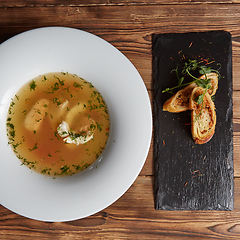 Image showing Beautiful presentation of the fish soup in a white plate, with b