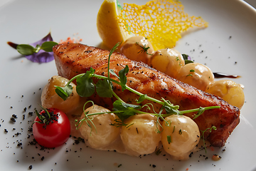 Image showing Roast salmon with potatoes on white plate. Shallow dof