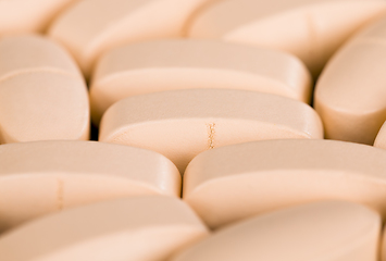 Image showing convex light-colored pills