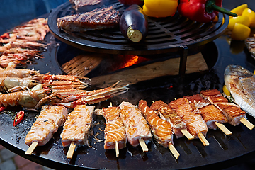 Image showing Grilled fresh seafood: prawns, fish, octopus, oysters food background Barbecue Cooking BBQ