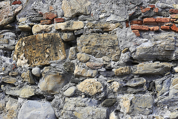 Image showing Old wall from stones of various shapes and red bricks