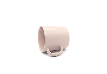 Image showing Empty light pink ceramic mug lying on its side