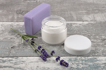 Image showing Open moisturizer and soap on weathered wood