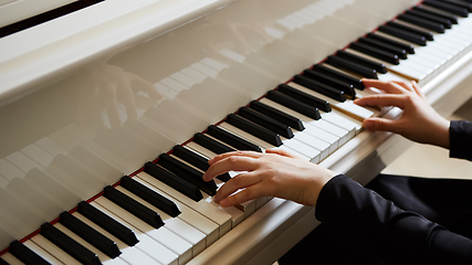 Image showing Womans hands on the keyboard of the piano closeup