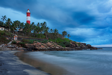 Image showing Gathering storm on beach and lighthouse on sunset. Kerala, India