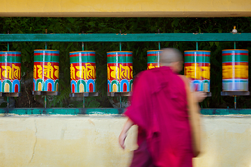 Image showing Buddhist monk rotating prayer wheels in McLeod Ganj