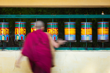 Image showing Buddhist monk rotating prayer wheels in McLeod Ganj