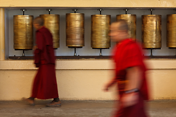 Image showing Buddhist monk rotating prayer wheels in McLeod Ganj