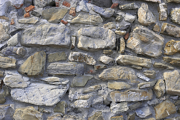 Image showing Very old wall from stones of various shapes and red bricks