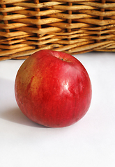 Image showing Ripe red appetizing apple on a basket and white background 