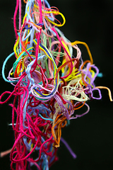 Image showing Multicolored tangled threads for needlework on black background