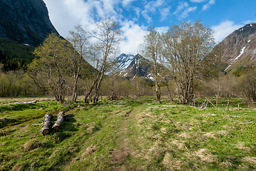 Image showing snow-covered mountain peak with open fields in the spring