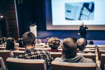 Image showing Speaker giving a talk in conference hall at business event. Rear view of unrecognizable people in audience at the conference hall. Business and entrepreneurship concept.