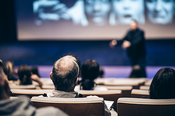 Image showing Speaker giving a talk in conference hall at business event. Rear view of unrecognizable people in audience at the conference hall. Business and entrepreneurship concept.