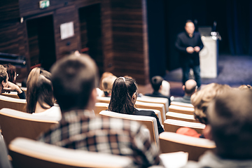 Image showing Speaker giving a talk in conference hall at business event. Rear view of unrecognizable people in audience at the conference hall. Business and entrepreneurship concept.