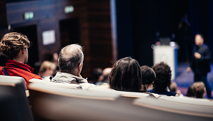 Image showing Speaker giving a talk in conference hall at business event. Rear view of unrecognizable people in audience at the conference hall. Business and entrepreneurship concept.