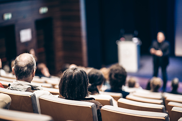 Image showing Speaker giving a talk in conference hall at business event. Rear view of unrecognizable people in audience at the conference hall. Business and entrepreneurship concept.