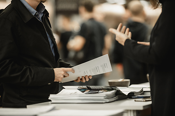 Image showing Business people exchanging business promotional materials and brochure on business meeting on trade-show. Business discussion talking deal concept.