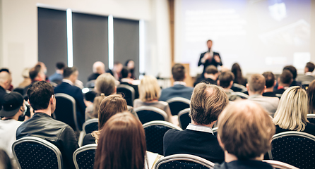 Image showing Speaker giving a talk in conference hall at business event. Rear view of unrecognizable people in audience at the conference hall. Business and entrepreneurship concept.