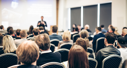 Image showing Speaker giving a talk in conference hall at business event. Rear view of unrecognizable people in audience at the conference hall. Business and entrepreneurship concept.