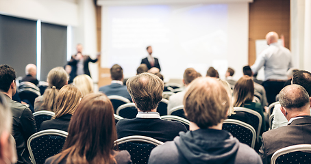 Image showing I have a question. Group of business people sitting in conference hall. Businessman raising his arm. Conference and Presentation. Business and Entrepreneurship