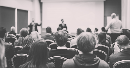 Image showing I have a question. Group of business people sitting in conference hall. Businessman raising his arm. Conference and Presentation. Business and Entrepreneurship