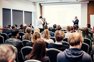 Image showing I have a question. Group of business people sitting in conference hall. Businessman raising his arm. Conference and Presentation. Business and Entrepreneurship