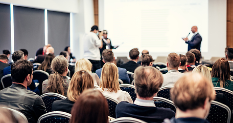 Image showing I have a question. Group of business people sitting in conference hall. Businessman raising his arm. Conference and Presentation. Business and Entrepreneurship