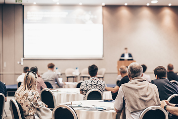 Image showing Speaker giving a talk in conference hall at business event. Rear view of unrecognizable people in audience at the conference hall. Business and entrepreneurship concept.