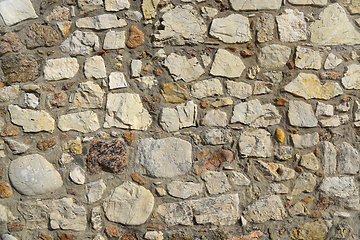 Image showing Old wall texture of various stones lit by the sun